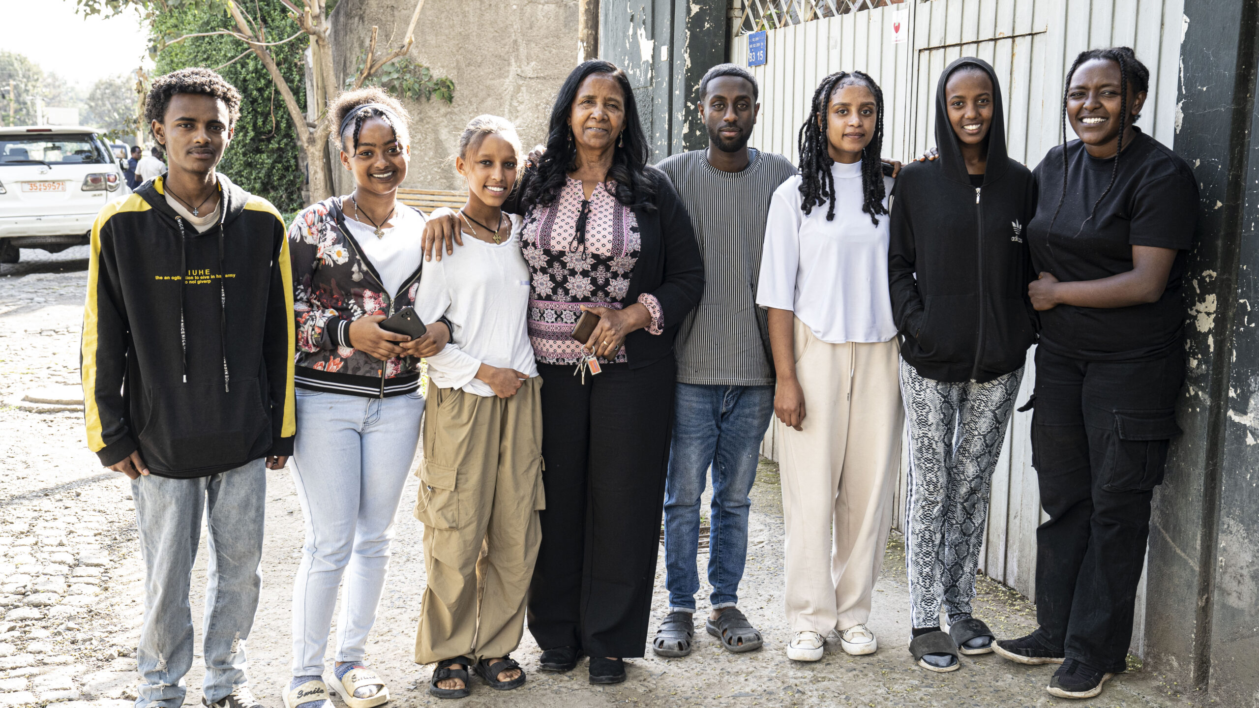 Founder Mulu standing proudly alongside a group of confident young Ethiopian entrepreneurs from the Collaborative Ventures program as they launch their co-owned business ventures.