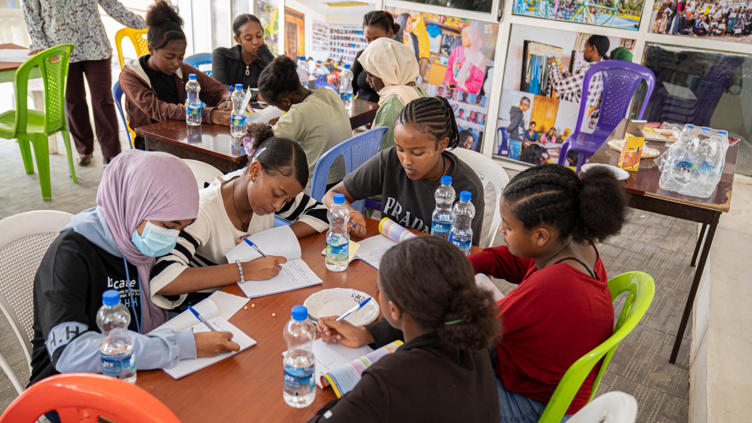 Ethiopian students writing in their notebooks and collaborating during a 